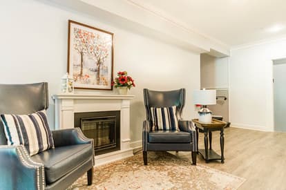 Lobby sitting area with two chairs and fireplace. 